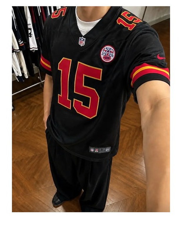 Customer photo of a black American football jersey with red numbers worn out of the door