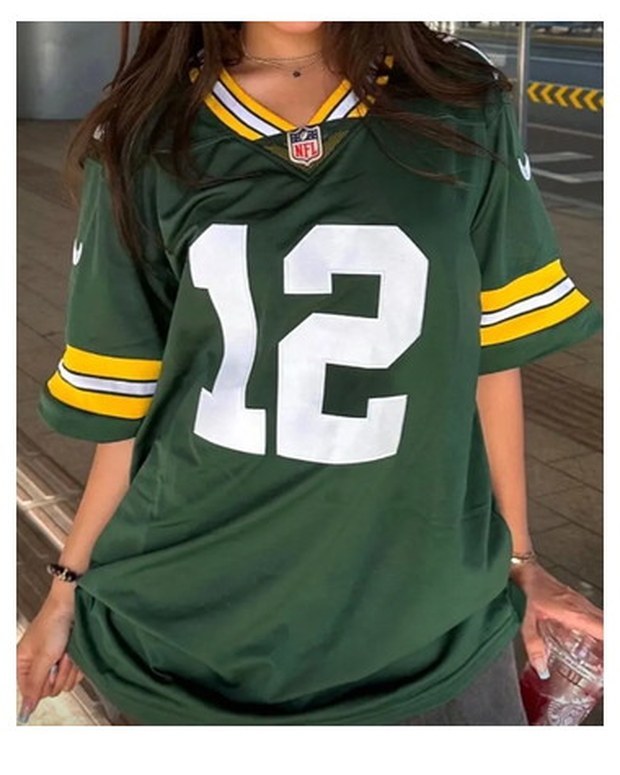 Customer photo of a green and gold American football jersey with over-long sleeves