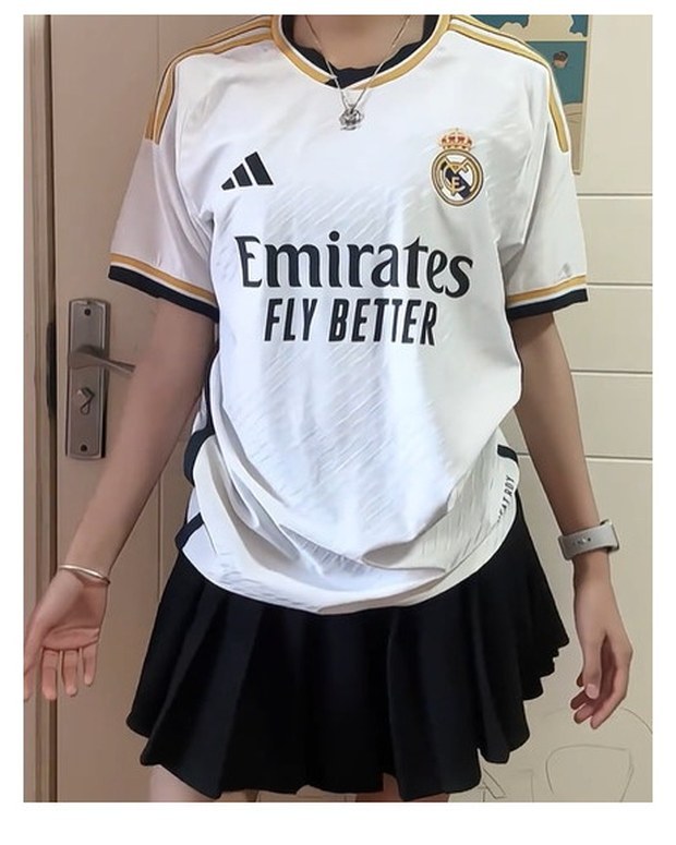 Customer photo of a white and gold football home shirt worn with a black skirt