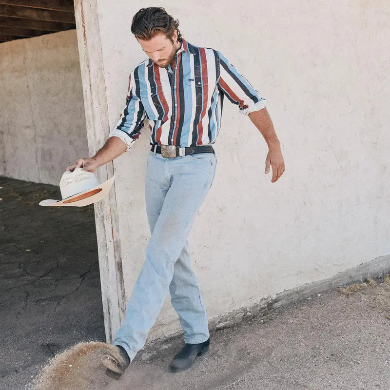 Man wearing light blue western jeans in a casual ranch-inspired setting