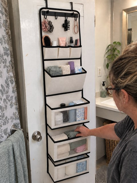 Bathroom door organizer holding towels and toiletries