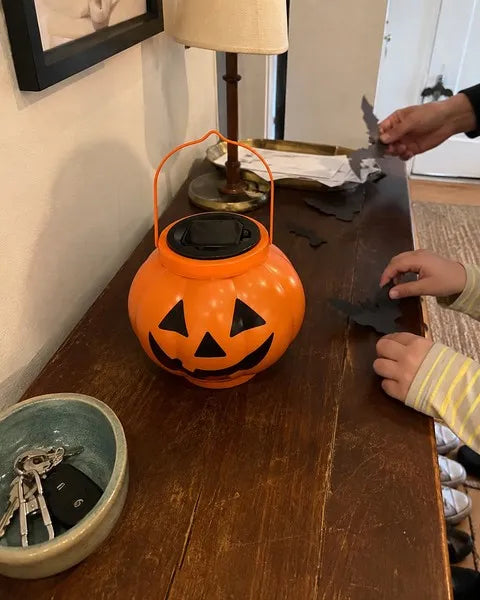Family decorating an entryway with a pumpkin solar lantern