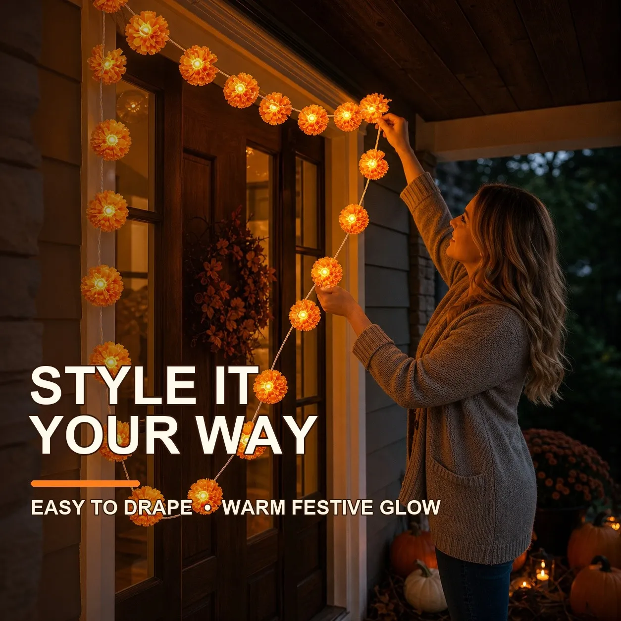 Woman arranging glowing marigold flower lights around a covered front doorway