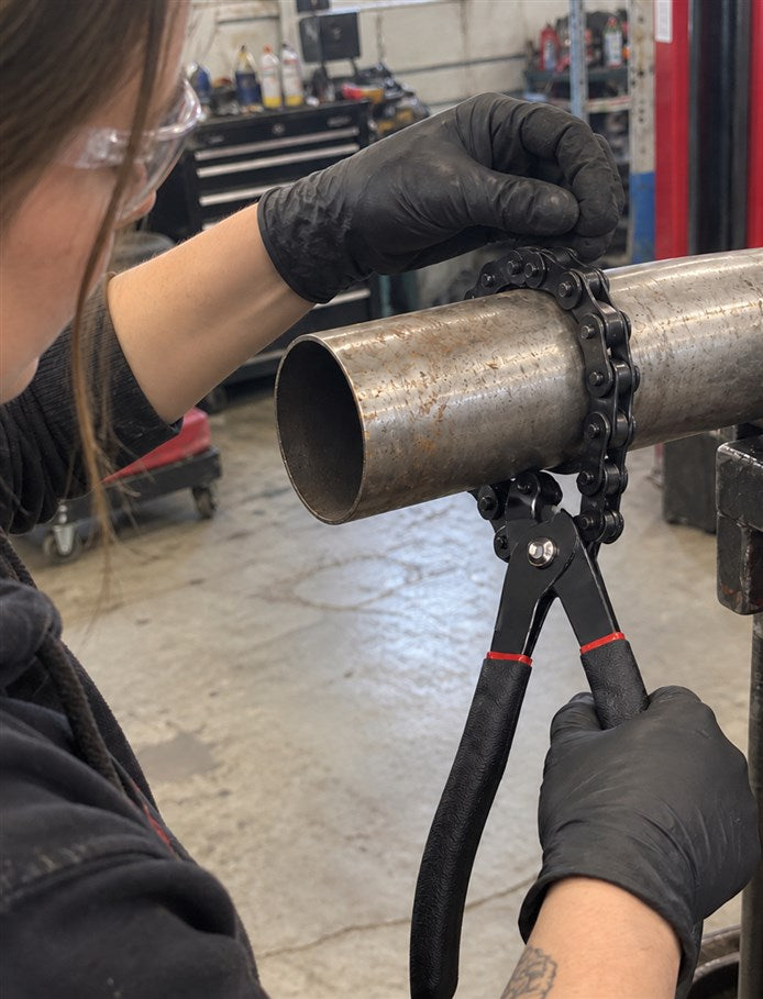 Technician hooking the chain around an exhaust pipe section