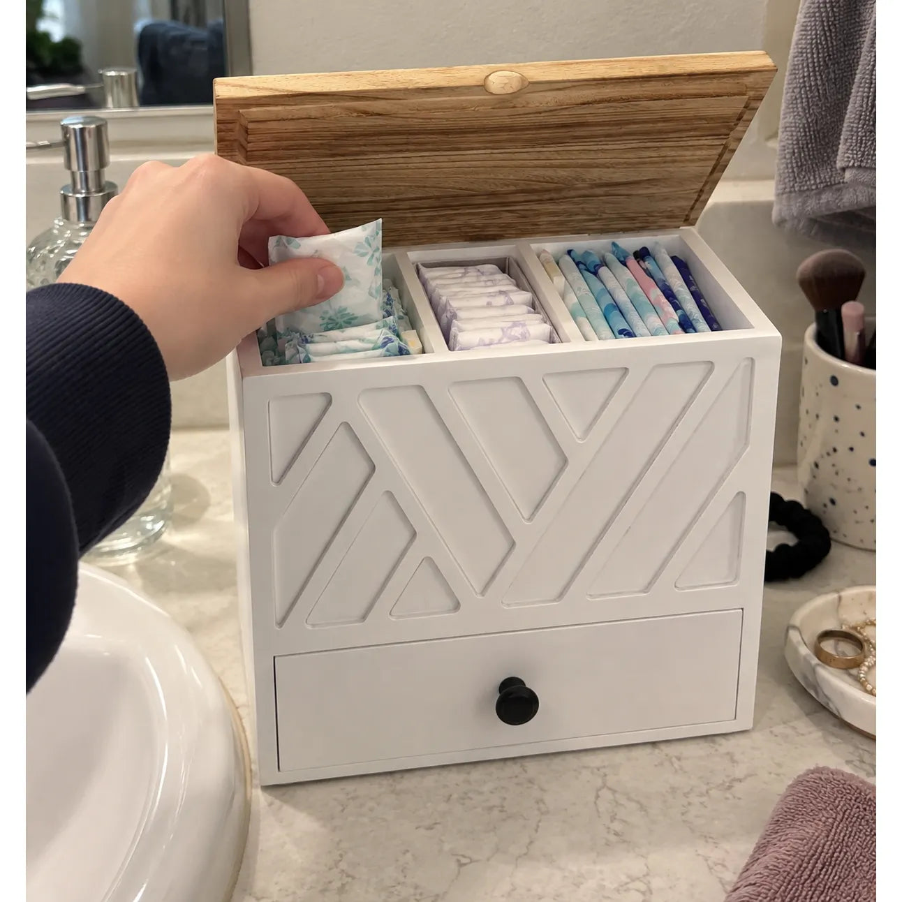 Hand refilling an open organizer on a vanity