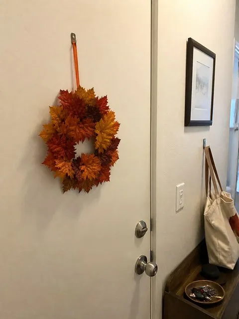 Mini maple leaf wreath decorating a compact apartment entry door