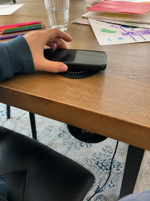 Phone charging at a family craft table