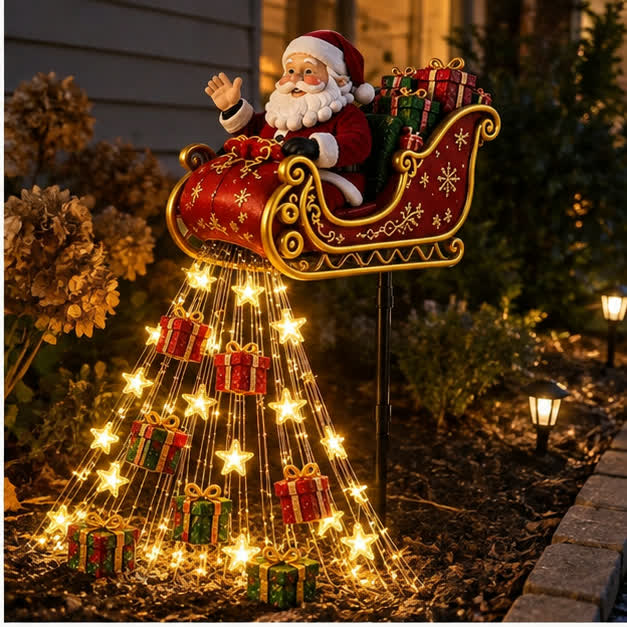 Casual nighttime phone photo of the Solar Santa sleigh cascade in a garden bed