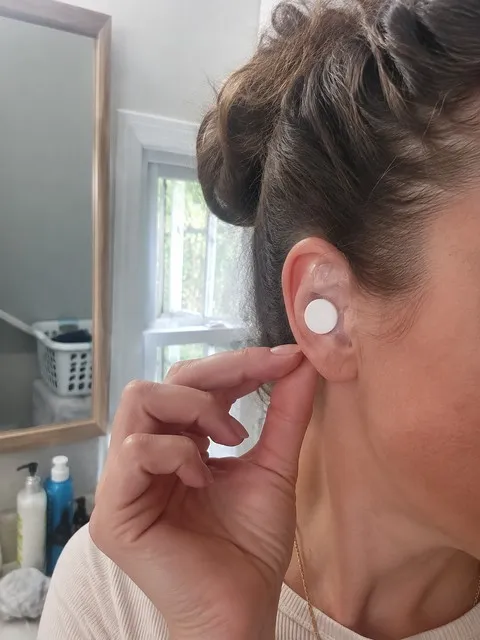 Adult wearing a clear ear cover before washing her hair