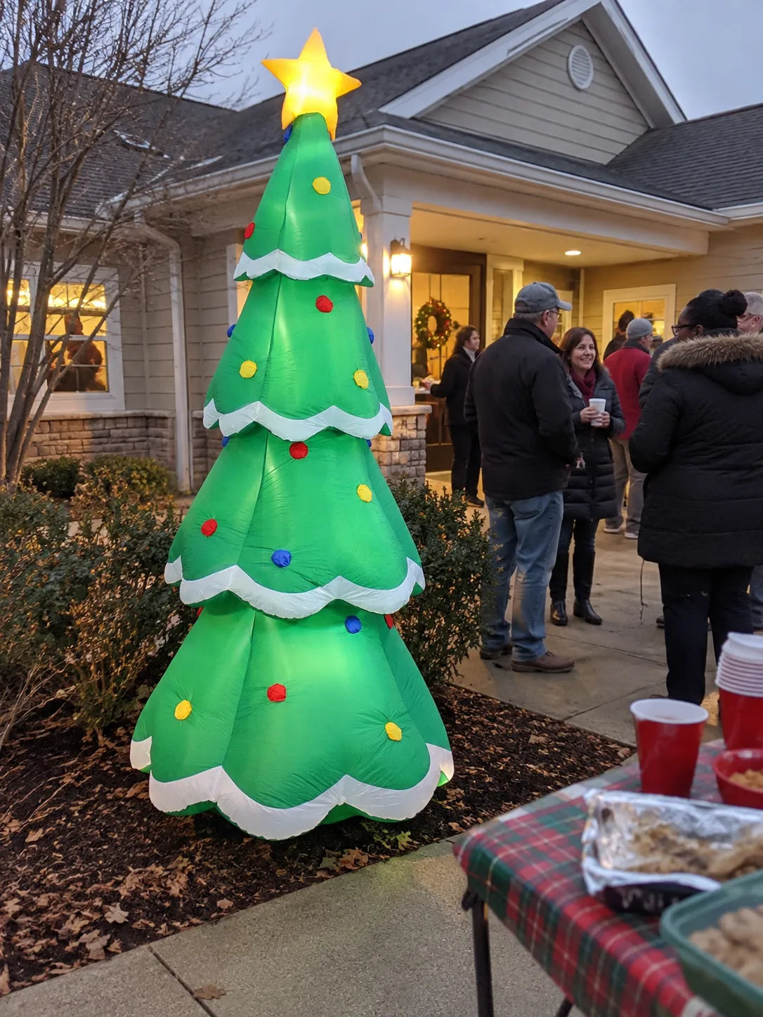 Inflatable tree beside a neighborhood holiday gathering