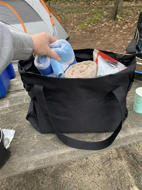 Black storage tote packed on a campsite table