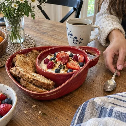 Wine red divided ceramic bowl with yogurt, berries, and toast at breakfast