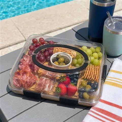 Customer-style poolside photo of the closed clear-lidded snack board
