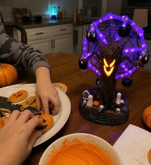 Family hands reaching for Halloween cookies beside the glowing haunted Ferris wheel