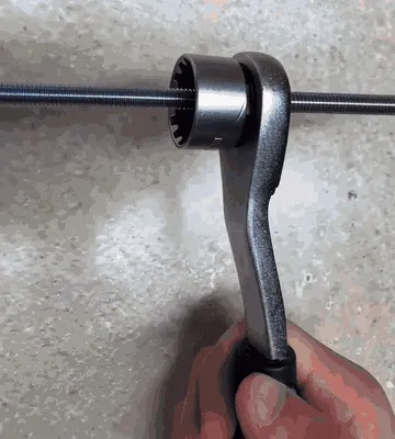 Pass-through ratchet working on a long threaded rod and shown beside an open engine bay