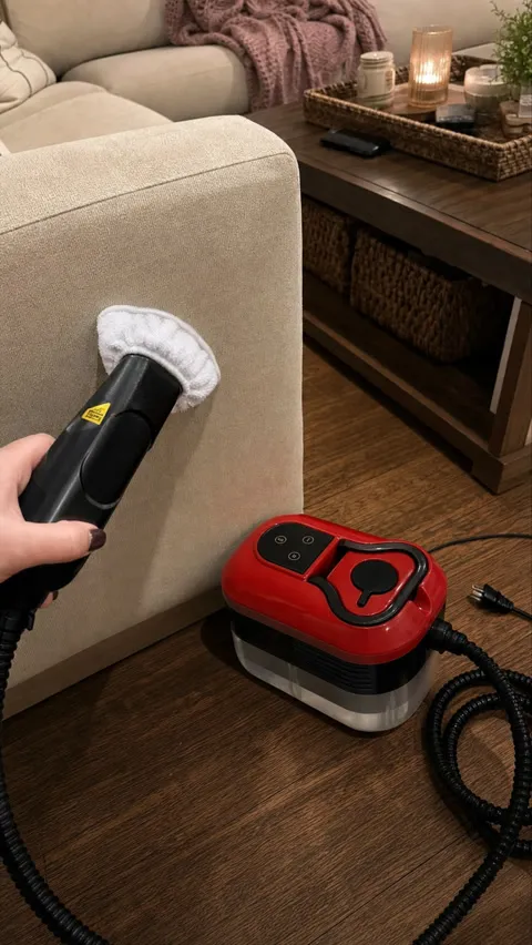 Customer using the red steam cleaner with cloth bonnet on a sofa