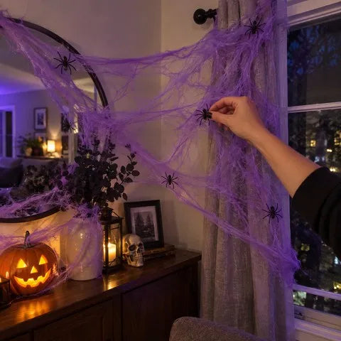 Purple spider web being decorated with small black spiders by a window
