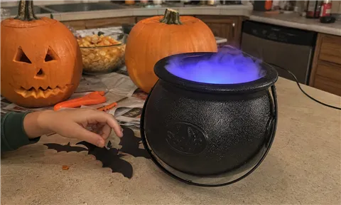 Casual family pumpkin-carving table with a glowing cauldron
