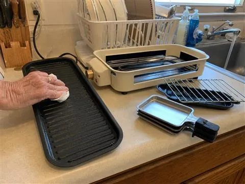 Removable grill parts being wiped down after dinner