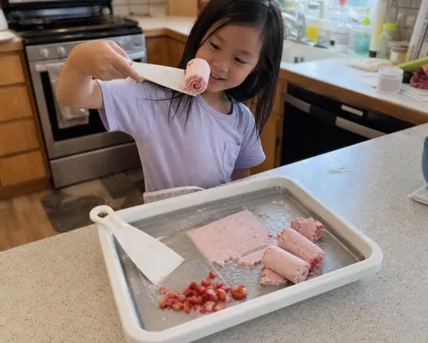 Child making strawberry ice cream rolls