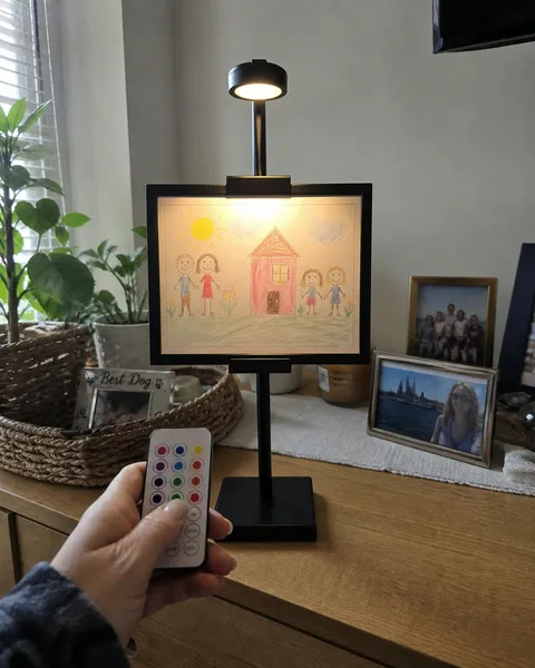 Lighted stand displaying a child's framed drawing at home