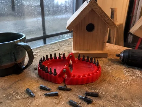 Red bit organizer beside a birdhouse project on a basement bench