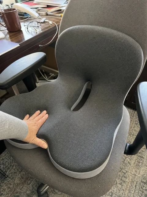 A hand pressing the integrated cushion on a home-office chair