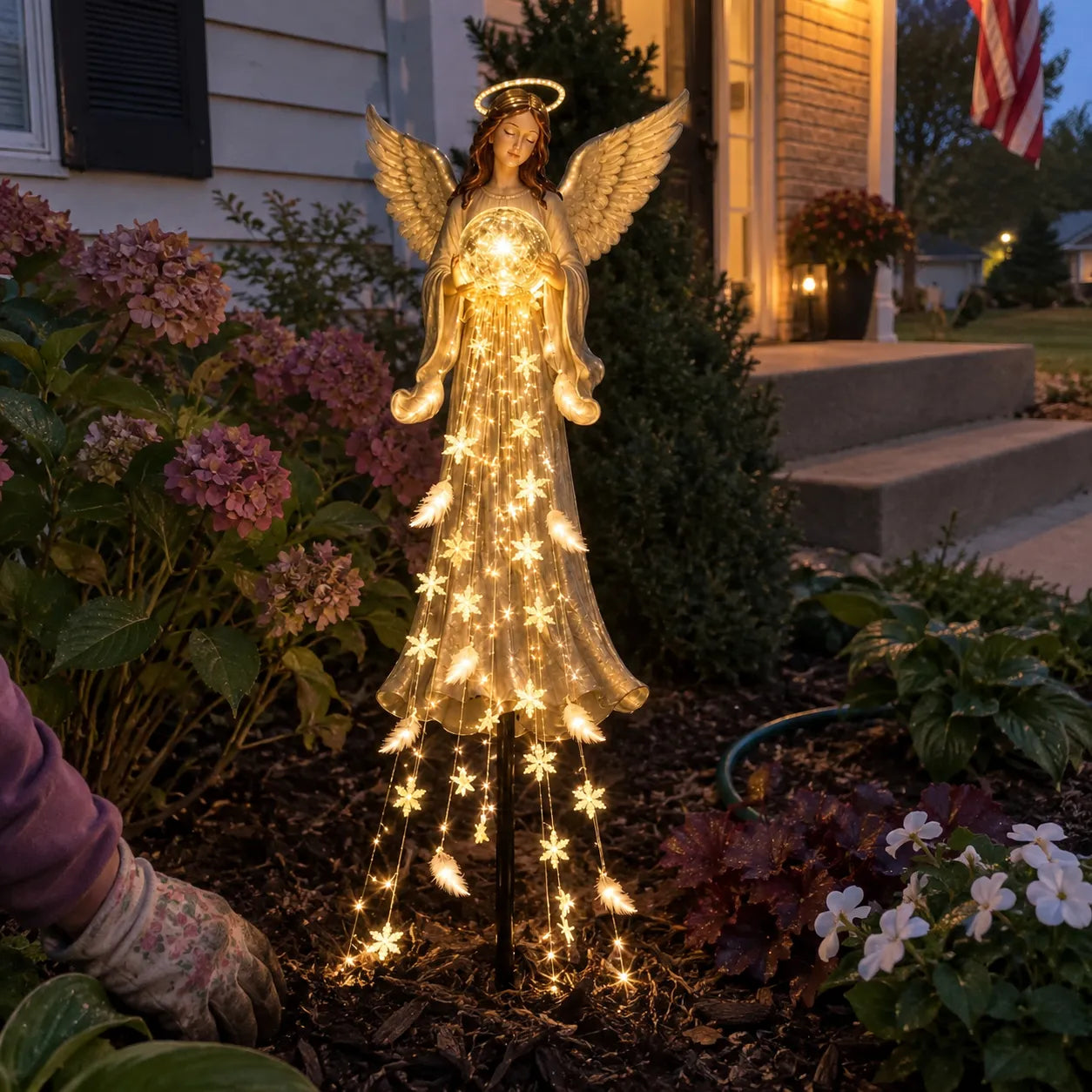 Glowing angel light in a front garden flower bed