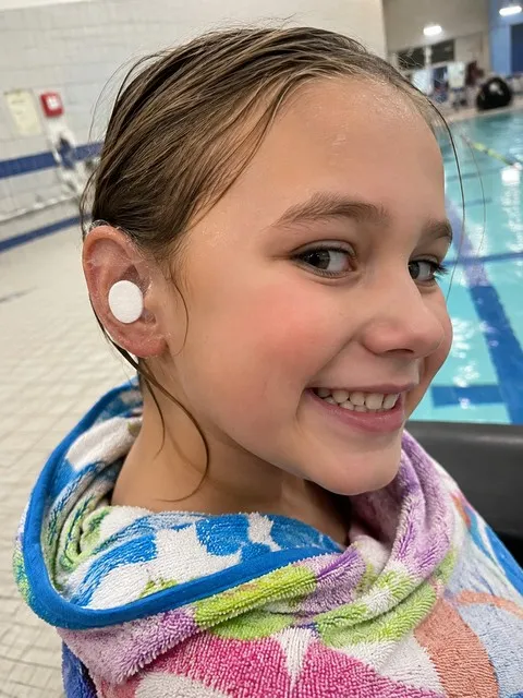 Child wearing a clear ear cover after swim class