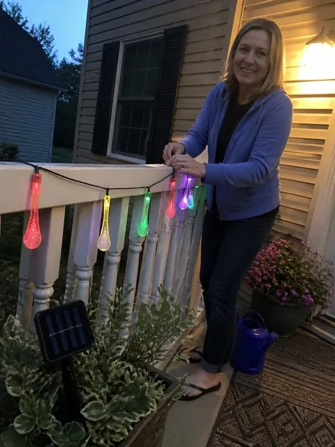 Multicolor solar waterdrop lights installed on a home porch railing