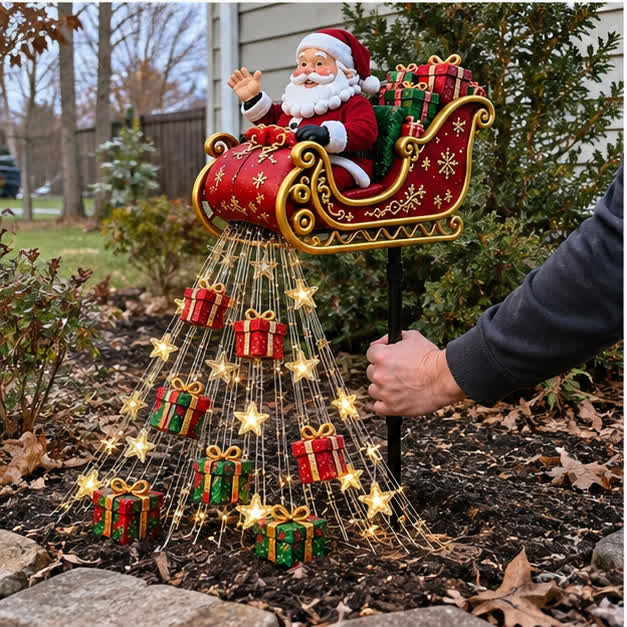 Casual daytime phone photo showing the Solar Santa sleigh ground stake being positioned