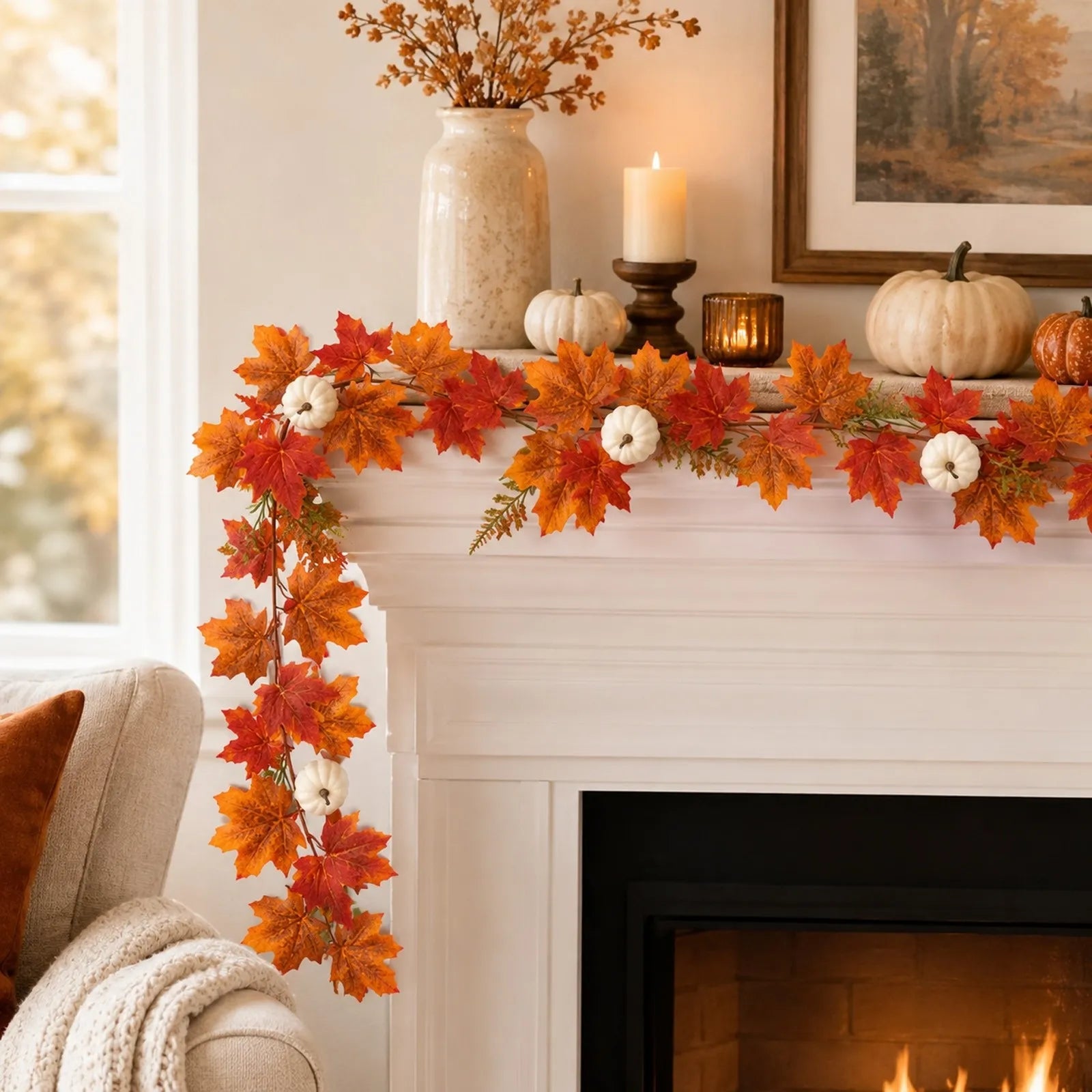 Artificial fall maple leaf garland with white pumpkins styled on a mantel