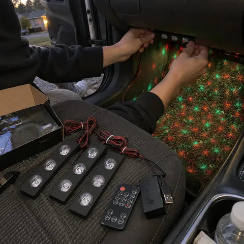 Driver installing a three-lens light bar in a compact car