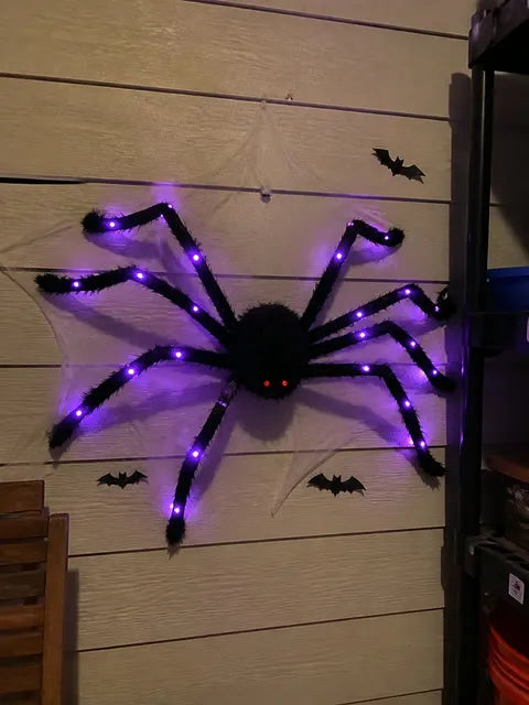 Purple light-up spider secured to a Halloween wall web