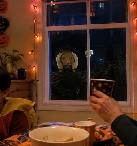 Creepy peeper prop surprising guests during a Halloween dinner