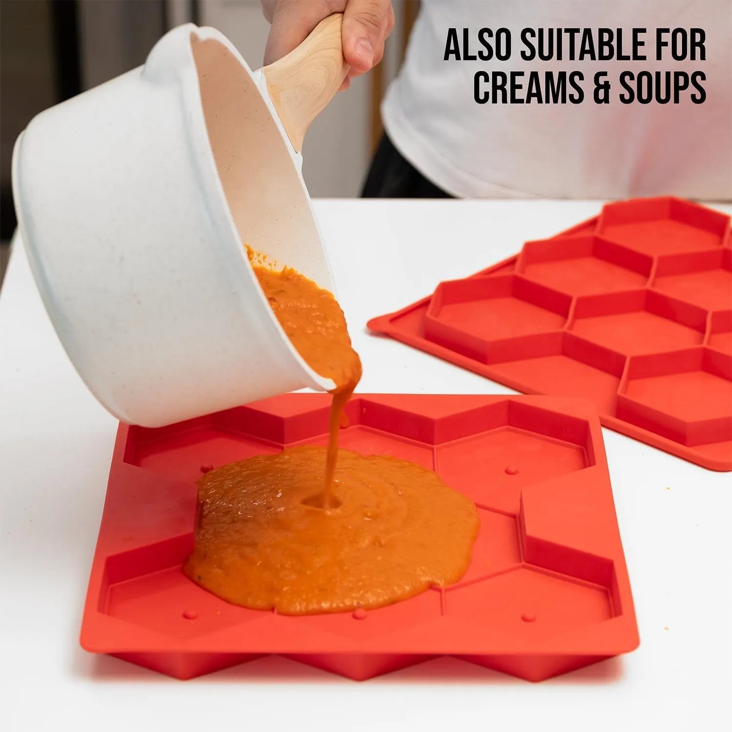 Sauce being poured into a red silicone portion mold