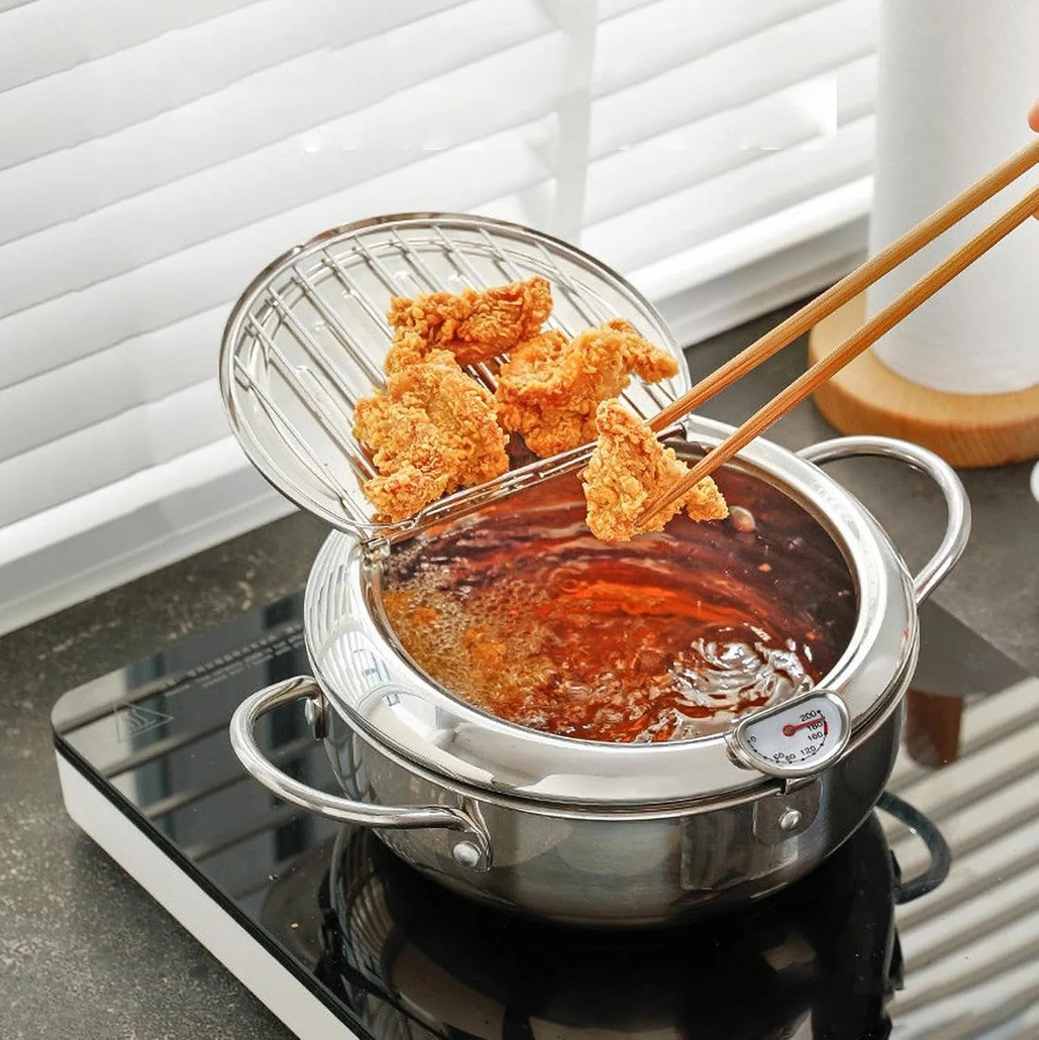 Fried chicken draining above the pot on the raised rack