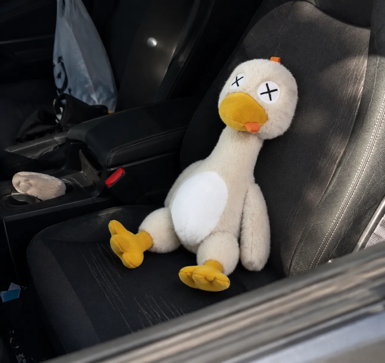Plush toy sitting casually in a car seat