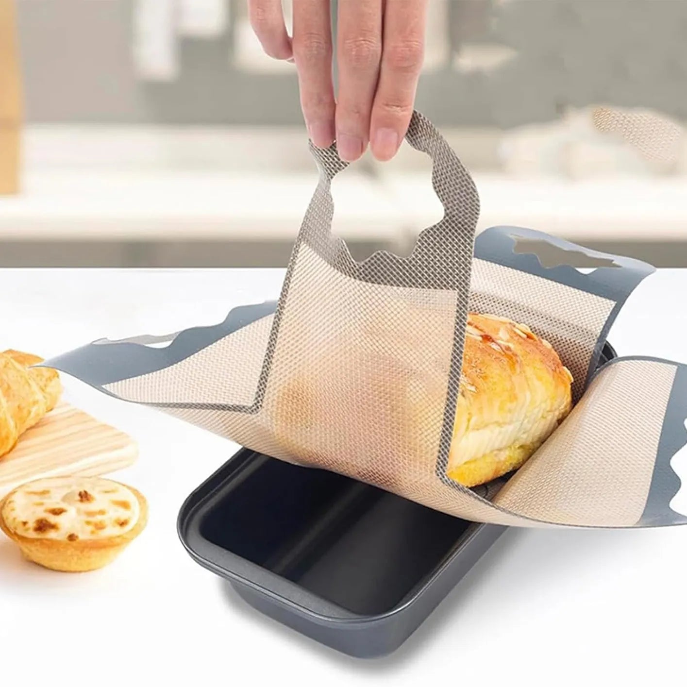 Fresh loaf lifted from a pan with four flexible handles