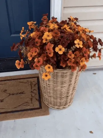 Artificial fall flower stems being arranged in porch planters