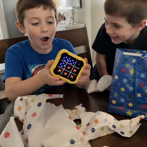 Children opening and trying the game at a birthday party