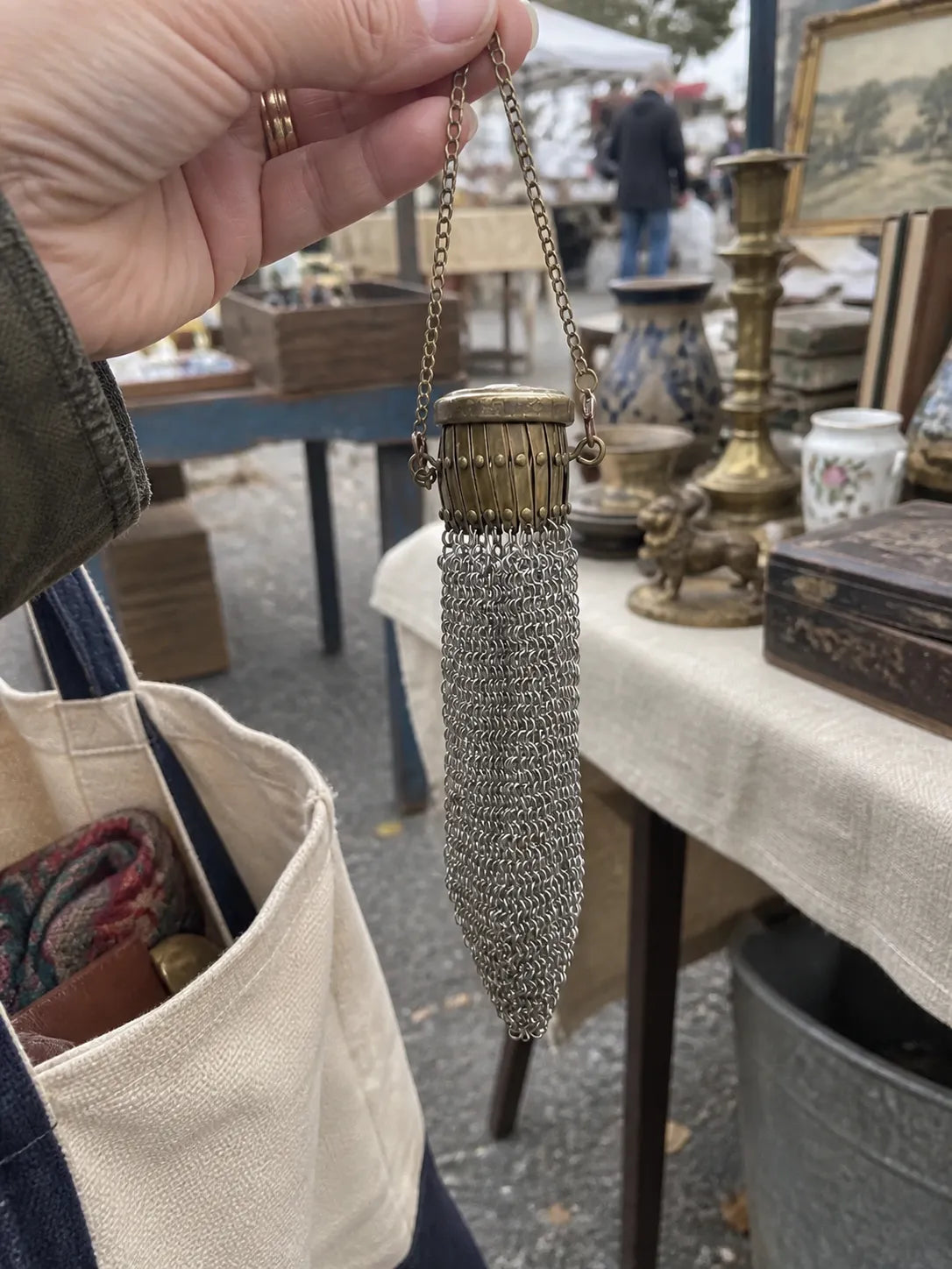 Closed vintage chain-mesh purse held at an outdoor vintage market
