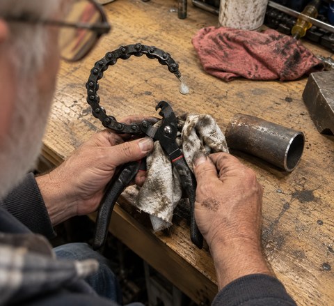 Home mechanic cleaning and oiling the chain cutter
