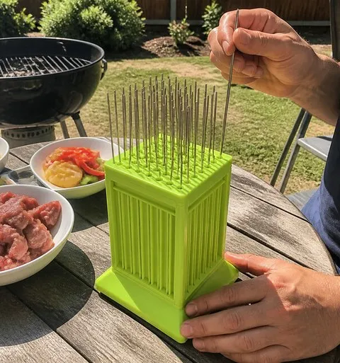 Kebab maker on a backyard barbecue table