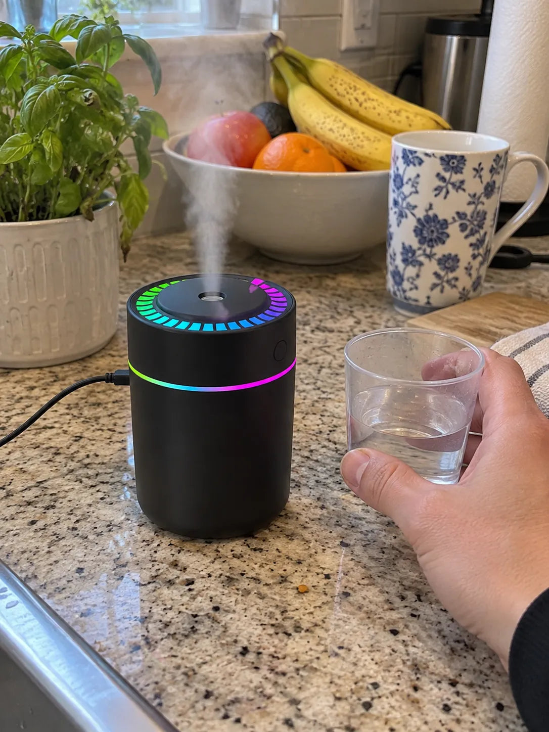 Black humidifier being refilled on a kitchen counter
