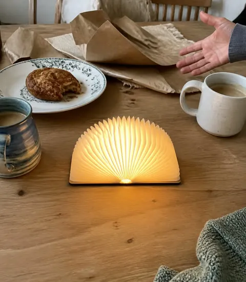 Compact folding book light glowing after a birthday gift was opened