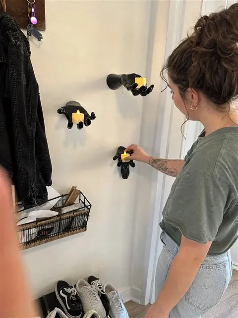 Three black hand candle holders in a lived-in apartment entryway