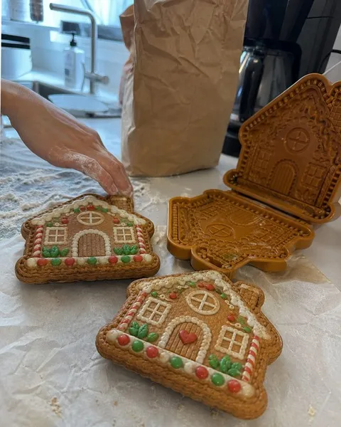 Homemade gingerbread-house mini pies cooling on parchment