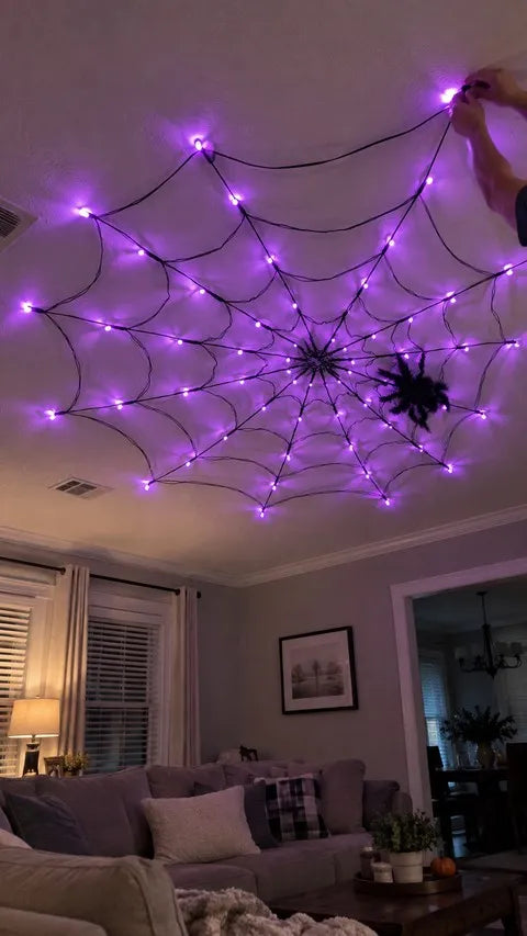 Purple spider web lights being adjusted on a living room ceiling