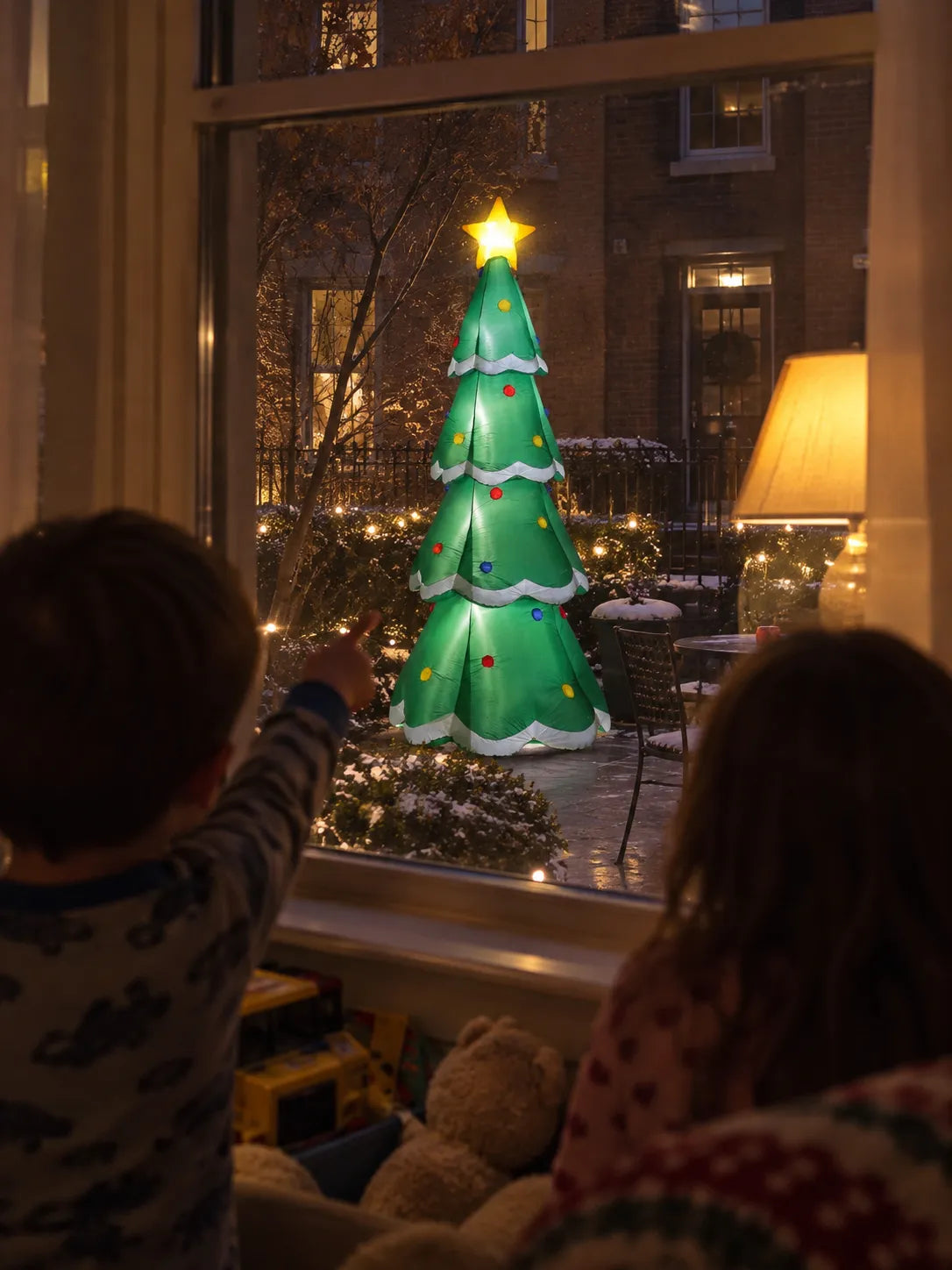 Children looking through a window at a glowing inflatable tree